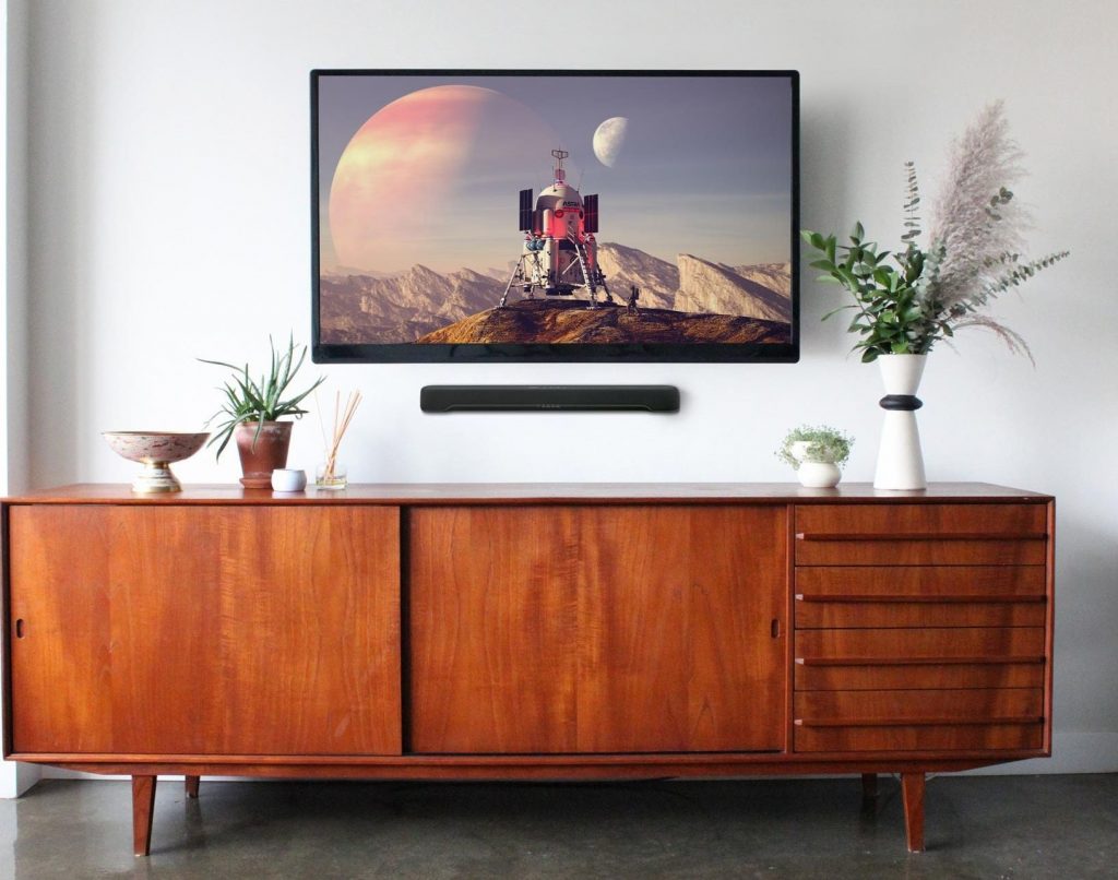 SR-C20A Large flat screen hung on living room wall with small horizontal sound bar hung under it.